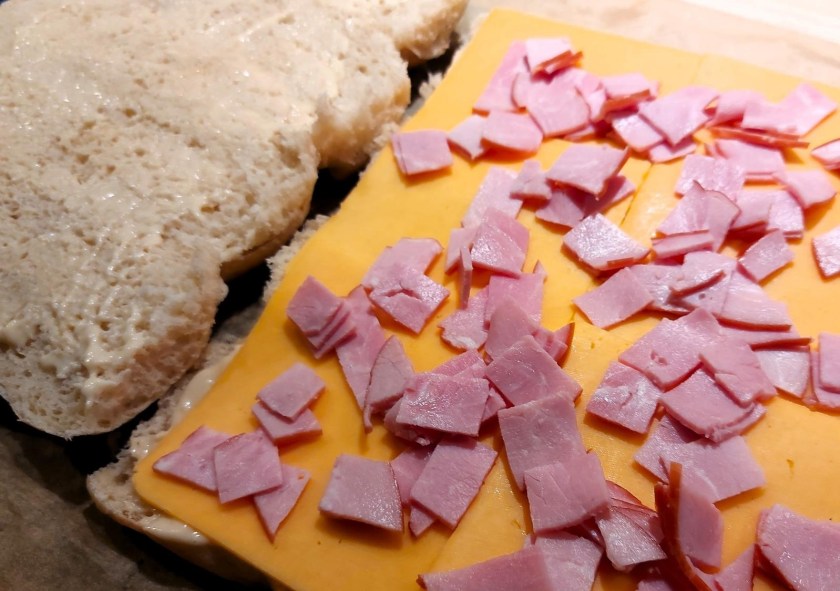 Brødet er smurt, ost og skinke er lagt på